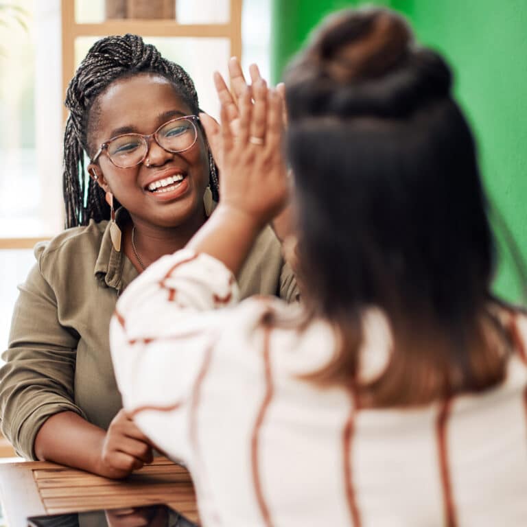 Nutrition counselor high fiving a client at eating disorder treatment after care planning
